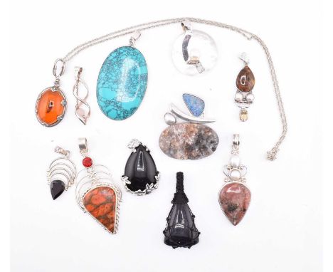 A quantity of silver and gem set necklace pendants and an amber pendant necklace. The eleven necklace pendants to include opa