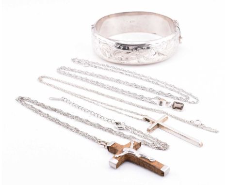 A hallmarked silver engraved bangle and three silver pendant necklaces. The lot to include a hallmarked silver engraved hinge
