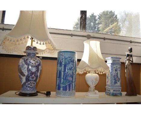 A large vase shaped lamp, a stick stand and other items.
