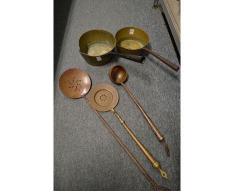 Two brass saucepans, an engraved copper ladle and two skimmers.