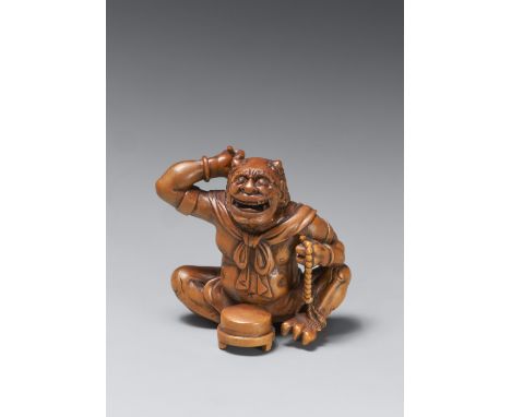 Großes Okimono-Netsuke. Fröhlicher oni. Buchsbaum. Spätes 19. Jh.Sitzend, vor ihm auf einem Tablett ein kleiner Gong, den er 