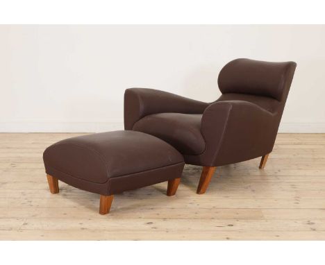 An 'Aston' armchair and ottoman,designed by David Linley for Linley, with swept armrests following through to a tapering back