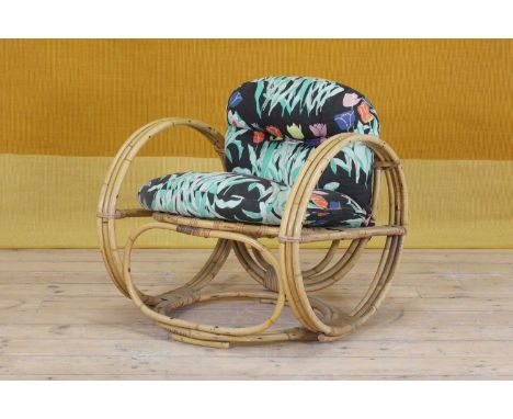 An Art Deco-style rattan and bamboo lounger,1970s, raised on hoop-shaped supports, with a seat and back cushion upholstered i