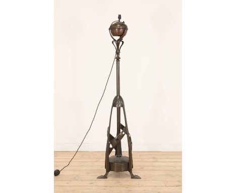 An Arts and Crafts standard lamp,converted to electricity, with an adjustable column, raised on a pierced torpedo-shaped stan