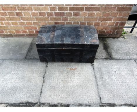 A METAL BOUND LEATHER COVERED DOME TOP TRUNK  with iron carrying handles, 74cm wide 46cm deep 37cm high