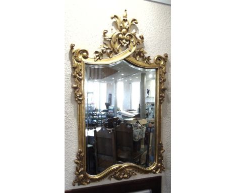 A LARGE DECORATIVE GILT FRAMED WALL MIRROR  of recent manufacture, 78cm wide 134cm high