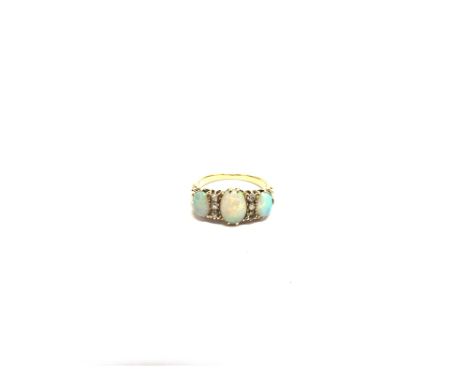 A THREE STONE OPAL RING  unmarked circa 1900, the graduated oval cabochons with trios of old single cut diamonds between, fin