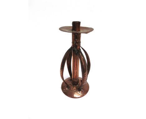 AN ARTS & CRAFTS COPPER CANDLESTICK  with four rivetted strapwork handles, stamped to base with monogram for Arthur John Sewa