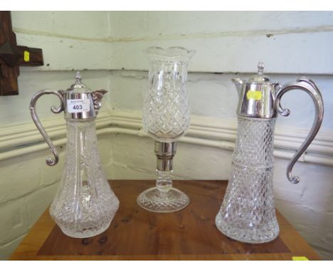 Two cut glass claret jugs with plated mounts and a cut glass lamp 