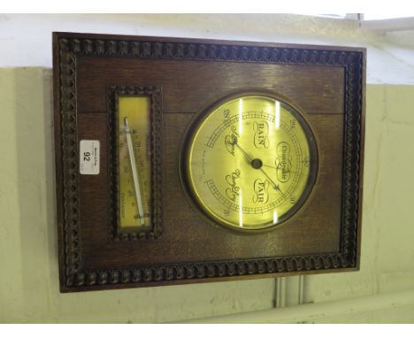 A 1930's rectangular oak barometer, with tongue and dart border, enclosing a brass dial and thermometer, 36.5cms x 26cms 