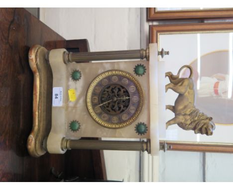 An early 20th century alabaster mantel timepiece, surmounted by a lion, on reeded columns, the French movement with exposed e