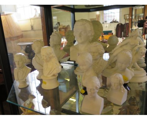 A bisque figure of a nude on a lion 24cm high and ten other bisque portrait busts