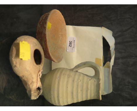 A Roman clay oil lamp 9cm long with certificate stating Harodian period from vicinity of Jerusalem; a Roman clay jug 11cm hig
