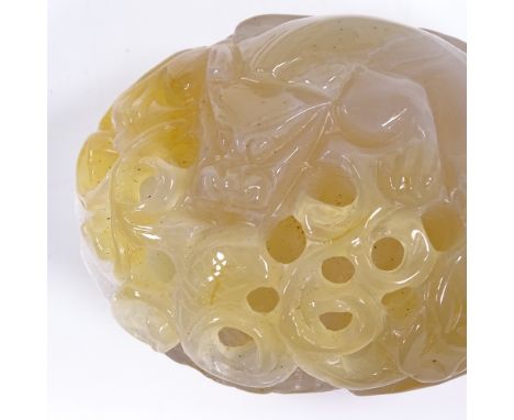 A Chinese reticulated carved and pierced jade pebble, depicting dragon and foliage, length 8cm