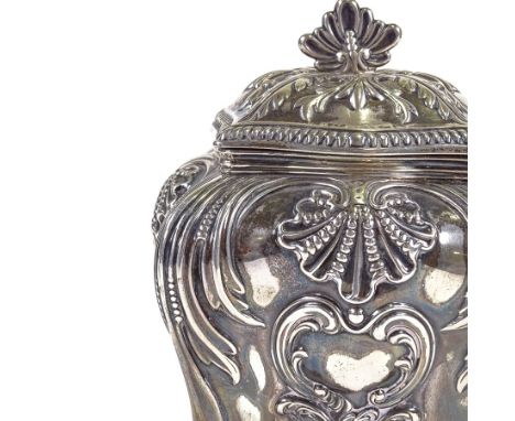 A late Victorian Art Nouveau silver tea caddy, square bombe form with relief embossed acanthus leaf and foliate decoration, b