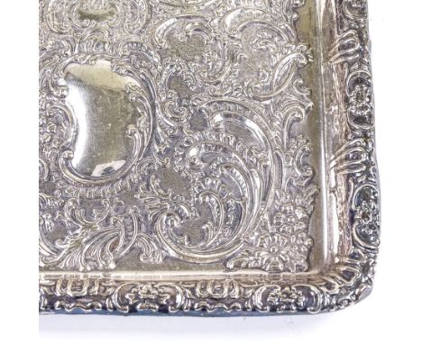 An Edwardian rectangular silver dressing table tray, relief embossed foliate and floral decoration with vacant cartouche, by 