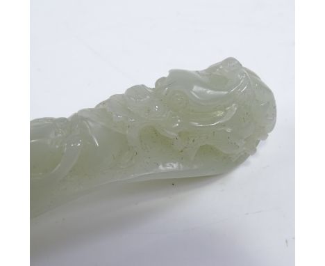 A Chinese celadon jade relief carved and pierced dragon and monkey design pendant, length 8cm 