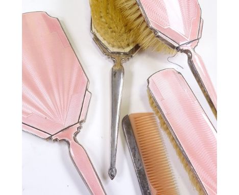 An Art Deco 5-piece silver-back pink enamel dressing table set, comprising hand mirror, 2 hand brushes, clothes brush and com