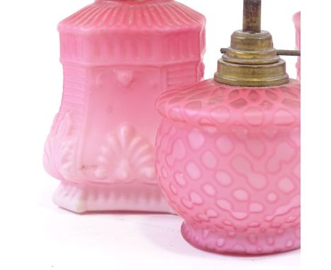 A pair of Victorian pink satin glass oil lamps of small size, relief moulded decoration and original brass mounts, height 14c