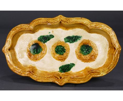 A SanCai "Lotus-Bloom" Lobed Oval Dish, Liao Dynasty, the shallow dish with a flat amber-glazed rim decorated with a floral s