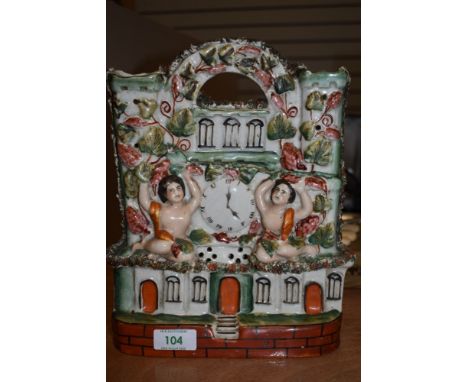 A ceramic Staffordshire flatback of a continental abode adorned with two cherubs and foliage
Condition Report slight hairline