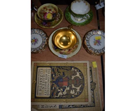 A selection of decorative cups and saucers and small plates, including two variations of Aynsley 'Orchard gold' having fruit 