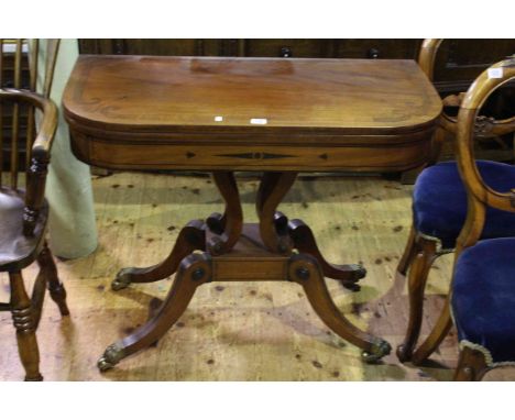 Regency mahogany and ebony inlaid fold top card table on brass paw feet