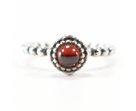 A Pandora silver ring in original box. The ring having a reeded band set with a red stone cabochon to the head. Marked 925. W