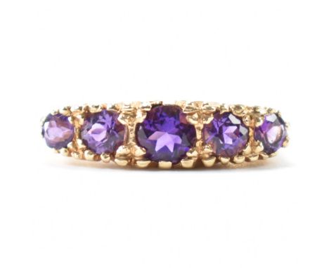 A hallmarked 9ct gold and amethyst five stone ring. The ring being set with five graduating round cut amethysts. Hallmarked L