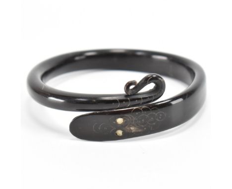 A 19th Century Victorian carved horn snake bangle bracelet. The bangle carved into a snake with a coiled tail with engraved d