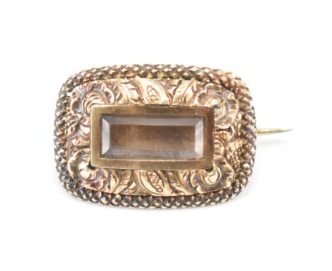 An antique yellow gold mourning brooch. The brooch of curved rectangular form having an unfilled centre panel surrounded by e