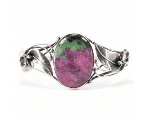 A silver and ruby zoisite Art Nouveau style bracelet. The bracelet being set with an oval ruby zoisite panel on pierced folia