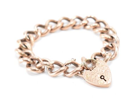 A vintage mid 20th Century gold curb link bracelet. The bracelet having hollow curb links with incised details with a heart c