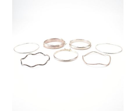 A group of vintage silver bangles. The lot to include; solid bangles, hinged bangles, plain band, twisted design, wave bangle