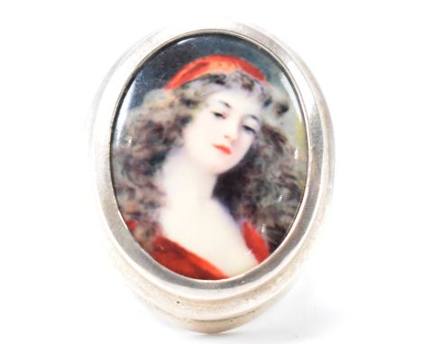 A 925 silver enamel plaque ring. The ring having a bezel set enamel plaque of a lady in red. Weight 9g. Size N.