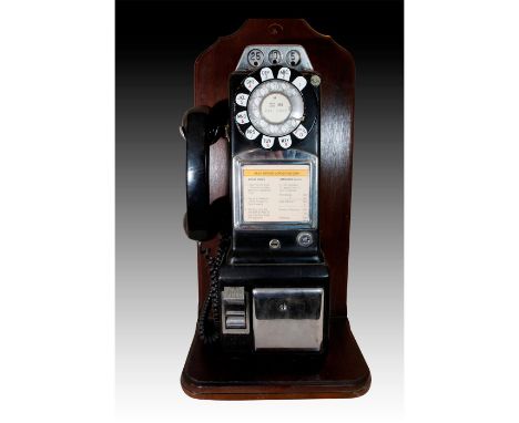 Displayed on a heavy wooden decorative base stand.An original pay phone produced for the Bell System. Multi coin operated. Wo