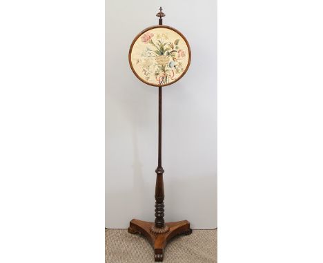 A Regency Rosewood Pole Firescreen, with turned support on shaped triangular base and scroll feet, with circular adjustable b