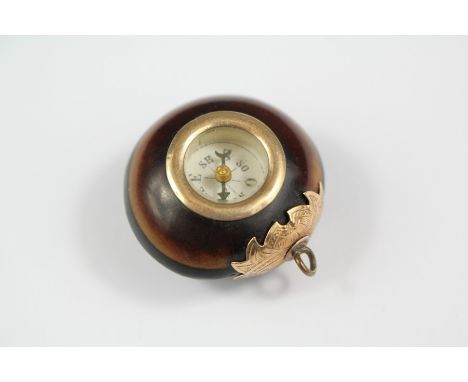 A Late Victorian 9ct Gold Mounted Nut Compass Pendant, approx 28 mm, on yellow metal loop.