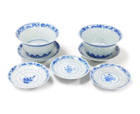 Two late 19thC Qing dynasty Rice pattern blue and white tea bowls, covers and stands, and a further lid, decorated with flowe