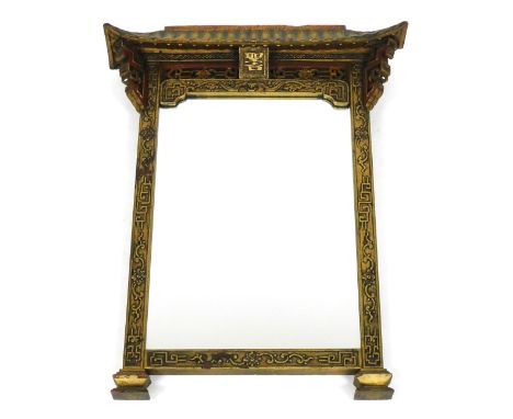 A late 19thC Chinese gilt wood and red stained wall mirror, carved in pagoda form, with a bat, flowers, foliate and geometric