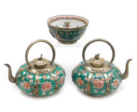A pair of Chinese porcelain and white metal teapots, decorated with flowers on a green ground, with a white metal handle spou