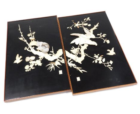 A pair of Japanese Meiji period black lacquer panels, worked in bone and mother of pearl, with birds and branches with blosso