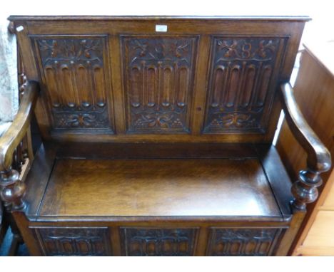 An early 20th century carved and panelled oak hall bench seat, 106cm wide