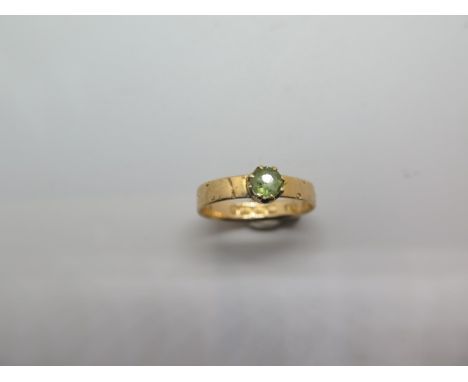 A hallmarked 18ct yellow gold peridot ring, size Z, approx 2.5 grams, hallmarks clear, wear to outer design 