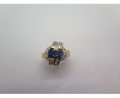 A hallmarked 18ct yellow gold sapphire and diamond crossover ring, size O, approx 7.6 grams, in good condition, some minor us