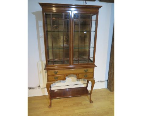 A good quality mahogany glazed display cabinet with two doors over a frieze drawer and two small drawers on shaped legs unite