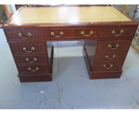 A good quality modern mahogany desk with a leather inset top above two slides and nine drawers, 137cm wide x 80cm high x 69cm