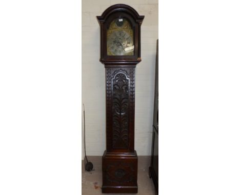 An 18th century oak longcase clock with later carved decoration, having arch top hood, full length door and plinth base, asso