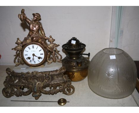 A French gilt metal clock and a brass oil lamp with engraved and star cut shade