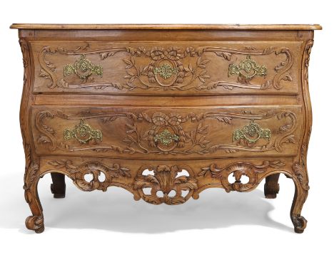 A Louis XV provincial blond walnut serpentine front commode, first quarter 18th century, the two floral carved drawers above 